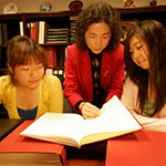 Three women sharing a book