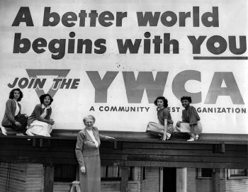 Women standing in front of a YMCA banner