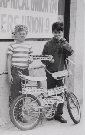 Two boys pose with Herald strike bumper stickers