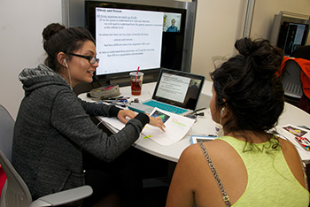 Two students using the shared media table at the oviatt library learning commons