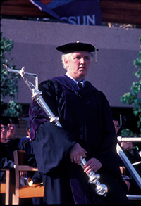 Dean Norman Tanis in academic regalia, mace bearer at a California State University, Northridge (CSUN) commencement ceremony, May 1983