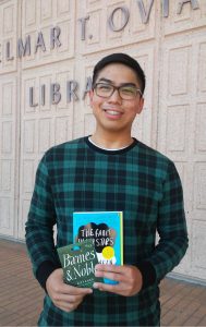 CSUN student Martin Navarro holding book while smiling