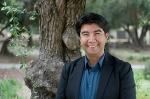 Photo of Professor Ruiz standing in front of a tree