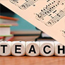 sheet music and blocks that spell "teach"