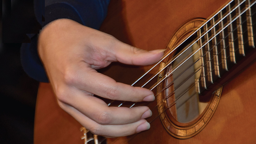 Person holding an acoustic guitar
