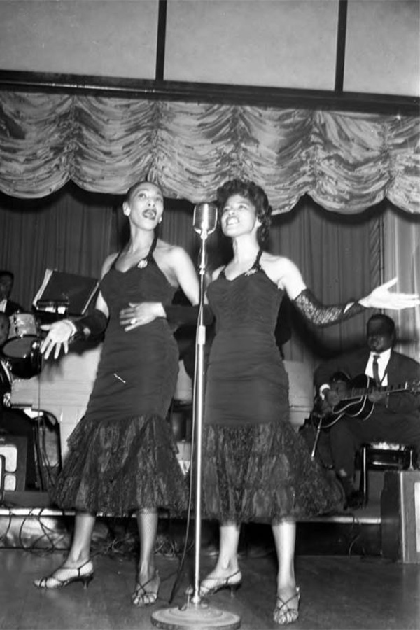 Men of Destiny - Two women dancing on stage.