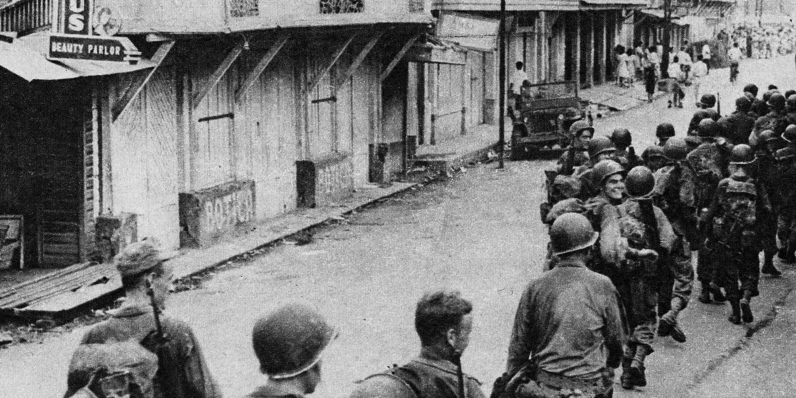 Soldiers marching past barracks