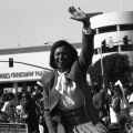Yvonne Brathwaite Burke waving while riding a limousine convertible in front of Baldwin Hills Crenshaw Plaza during the Kingdom Day parade. In 1992, Burke would be elected to represent the second district on the L.A. County Board of Supervisors. Guy Crowder Collection, 11.06.GC.N35.B5.47.158.34A.