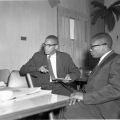 Malcolm X and Minister John Shabazz of Mosque No. 27 sitting at a table, Harry Adams Photograph Collection
