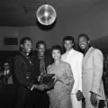 The Temptations with Gertrude Gipson (from the L.A. Sentinel) receiving a plaque for being the ""Nations Number One." Left to right: Melvin Franklin, Eddie Kendricks, Dennis Edwards, Otis Williams. Harry Adams Collection