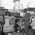 Yvonne Brathwaite Burke (left) and City Councilman Tom Bradley participate in a ribbon cutting ceremony in a shopping center parking lot five days before the run-off election for Los Angeles mayor against incumbent Sam Yorty. Yorty won the election. 1969. Digital ID: 11.06.GC.N120.B6.S7.31.56.12