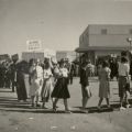 Line of women protesting, with a police officer visible in the background