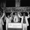 Maxine Waters (2nd from left), Jesse Jackson (center) and Stevie Wonder (2nd from right) stand at a lectern with raised clasped hands between an unidentified man and woman during a Black Women's Forum event at the Ambassador Hotel. Digital ID: 11.06.GC.N35.B6.21.59.10A