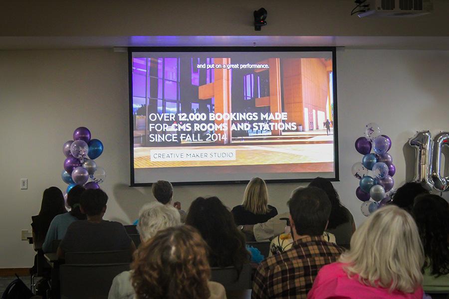 Attendees watching the premiere of 'A Decade of Creativity' on a projector screen