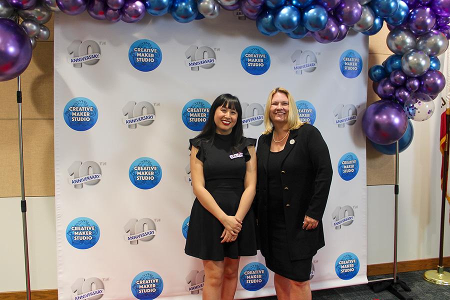  Learning Commons Lead, Eva Cohen and President Beck in front of the 10th anniversary photobooth.