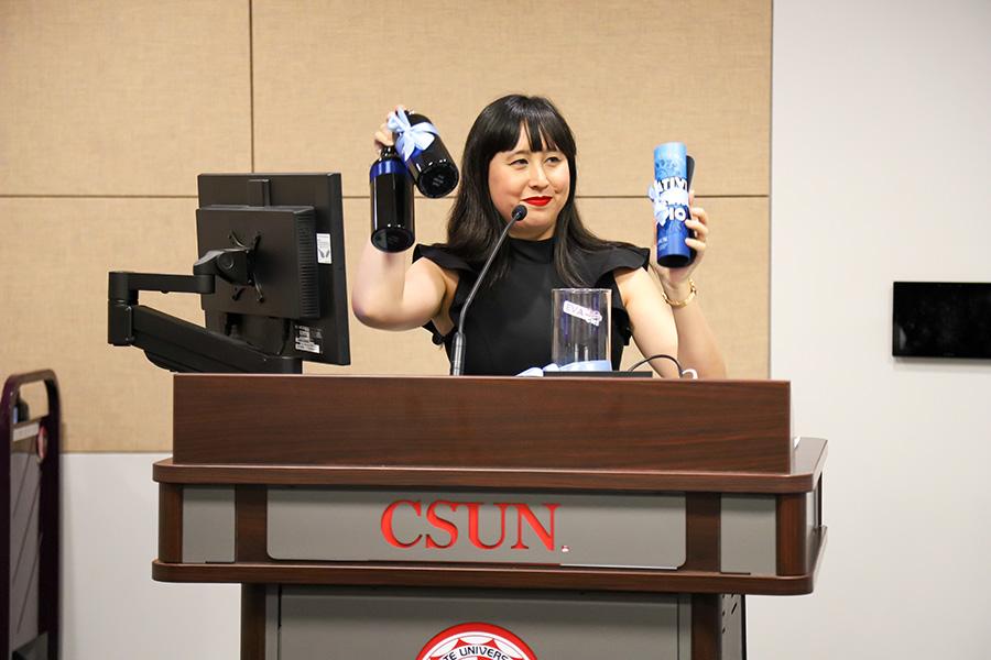 Eva Cohen holding some bottles in a gift raffle