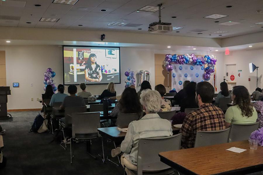 Attendees watching the CMS short film 'A Decade of Creativity' on a projector screen