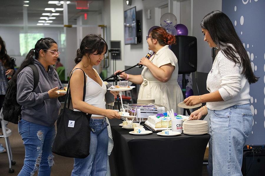 Students serving cake to attendees