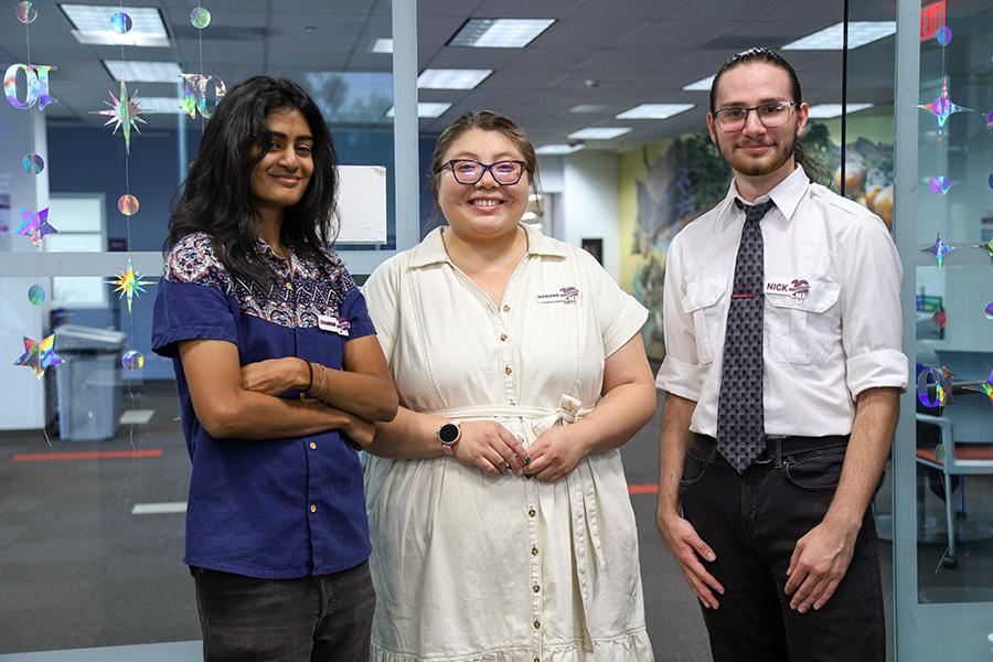 Three students posing inside the CMS