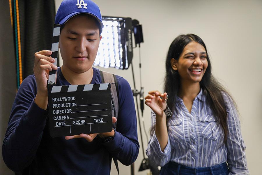 CSUN students inside the CMS production room playing with a slate and showing off a 3D printed slate keychain