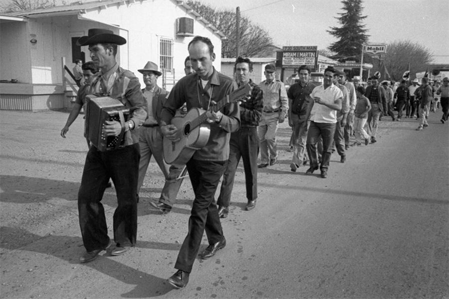 musicians leading a group of marchers down the street