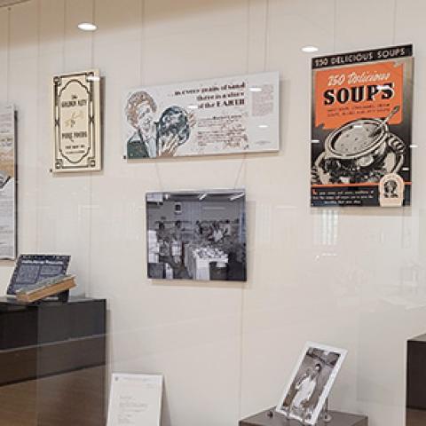 Display case with ads, photos and culinary books.