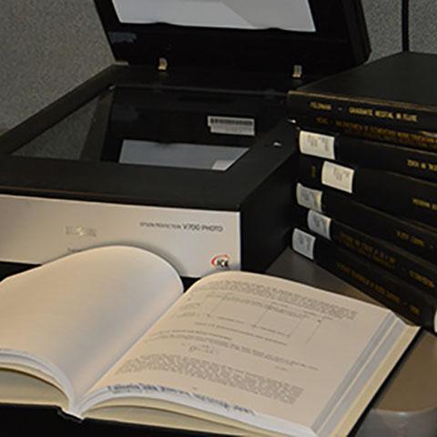 Scanning station and bound theses used as part of the Electronic Thesis and Dissertation Digitization Project.