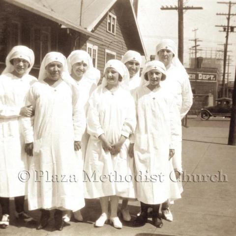 A group of women dressed in a white robe.