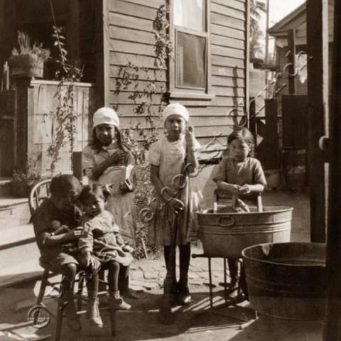 Kids standing next to a house