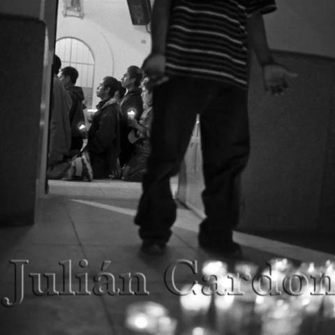 A child standing in front of lit prayer candles.