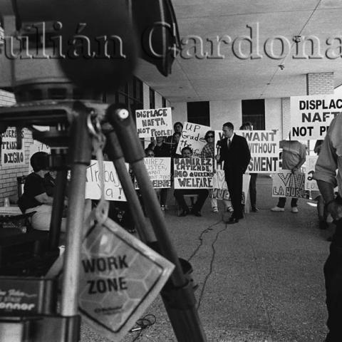 A news reporter reporting among protestors.