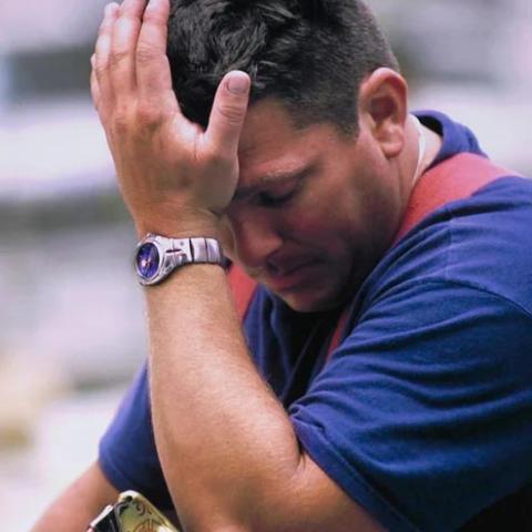 A man with his palm over his head