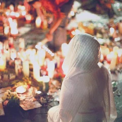A woman in a white dress offering prayers