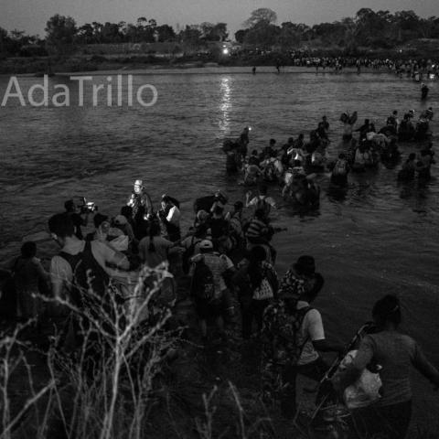 A large group of people crossing a river.