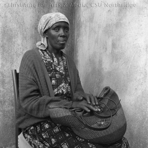 A portrait of a woman sitting on a chair.