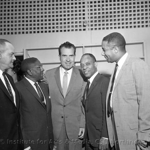 Few men standing with Richard Nixon.