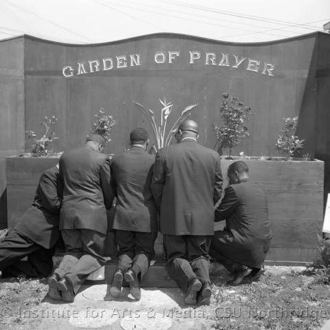 Men kneeling at the garden of prayer.