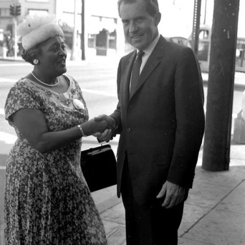 Woman shaking hands with Richard Nixon.