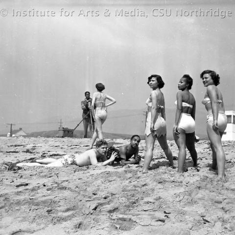 Woman on a beach and men clicking pictures