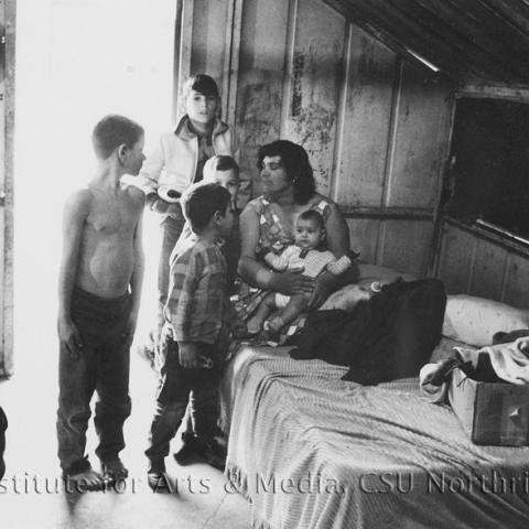 A woman sitting on a bed with children.