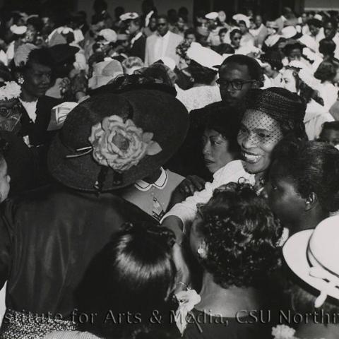 A woman greeted by a large crowd of people