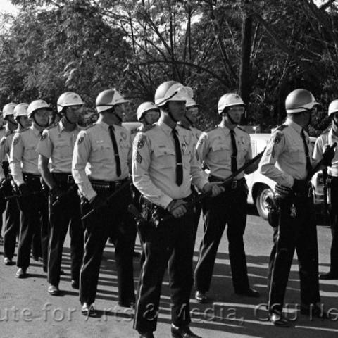 Police assembled holding batons.