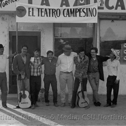 Eight men in front of a cafe