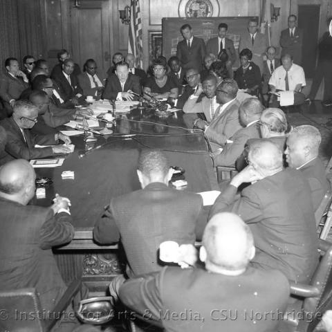 A group of men and women seated around a conference table.