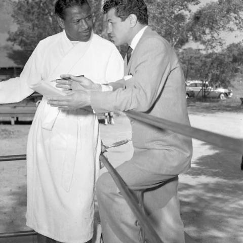Man in a suit talking to a man in a bathrobe