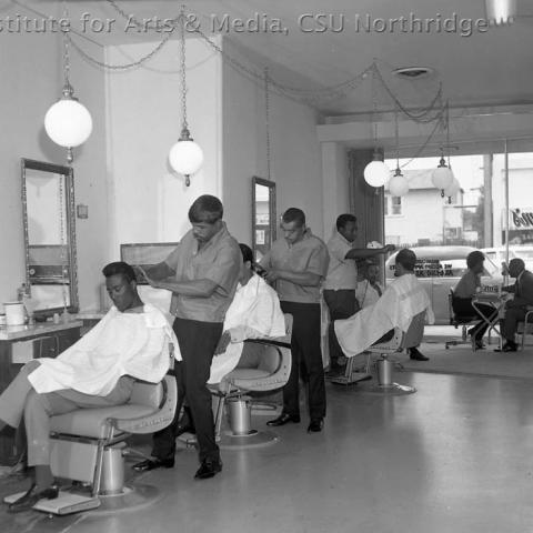 Barber shop interior with two customers and barbers