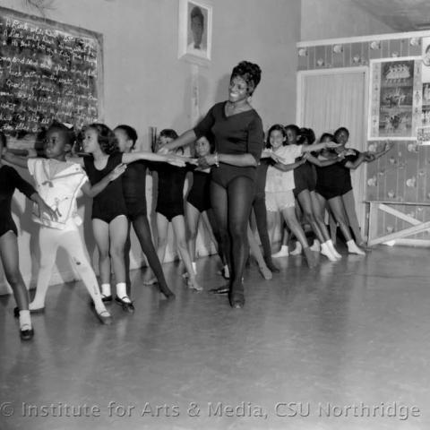 Woman teaching kids ballet.