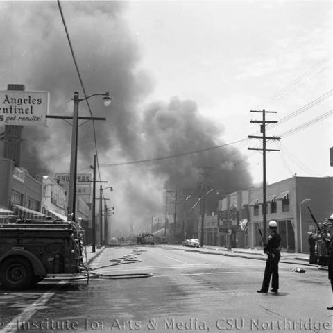 Fire truck and Firemen standing on the street with a lot of smoke.