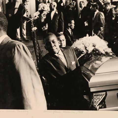 Teenagers carrying a coffin at a funeral.