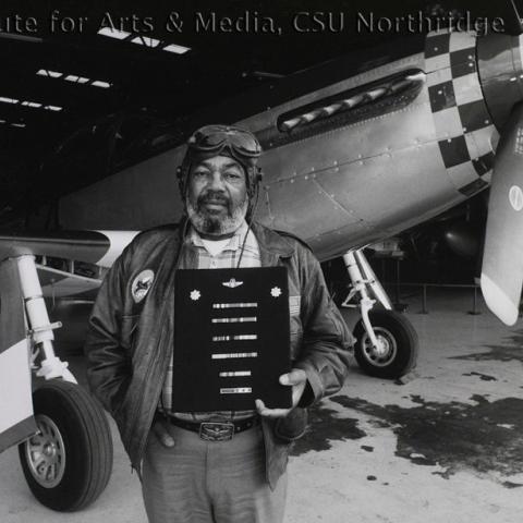 A pilot standing in front of a single engine airplane.